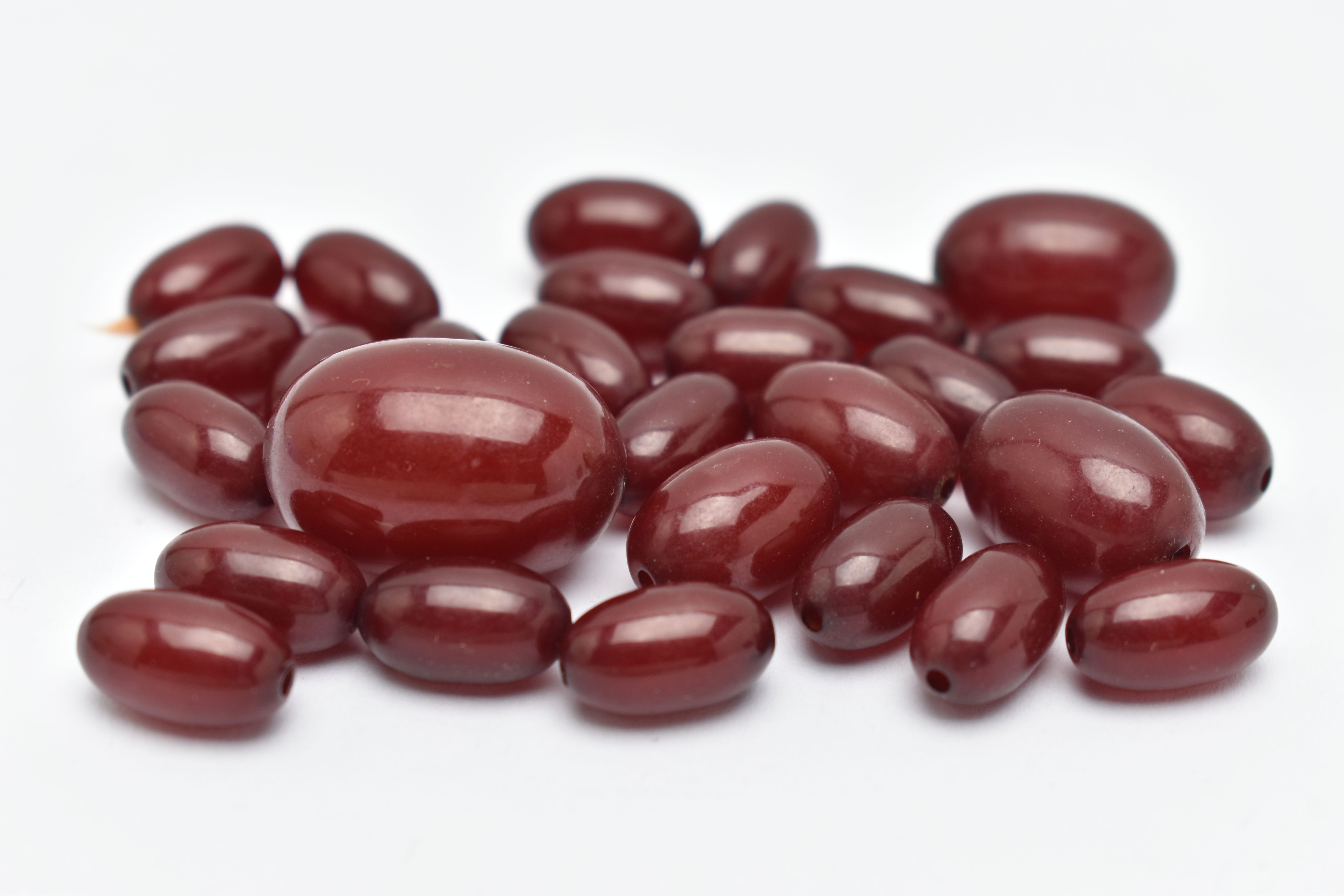 A SMALL QUANTITY OF CHERRY AMBER COLOUR BAKELITE BEADS, loose beads of an oval form, largest - Bild 3 aus 6