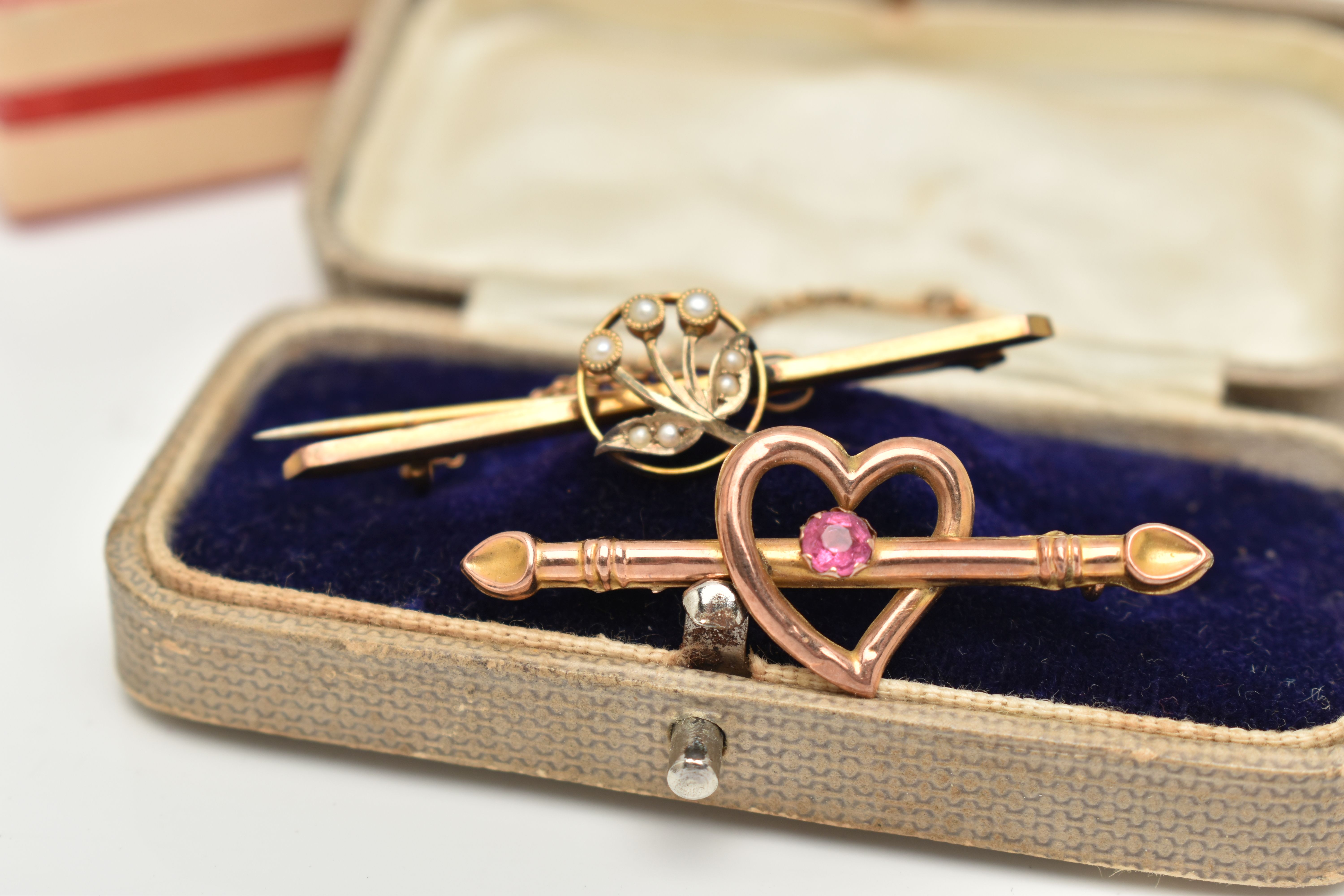 TWO EARLY 20TH CENTURY BROOCHES, the first an open work heart with bar set with a single pink