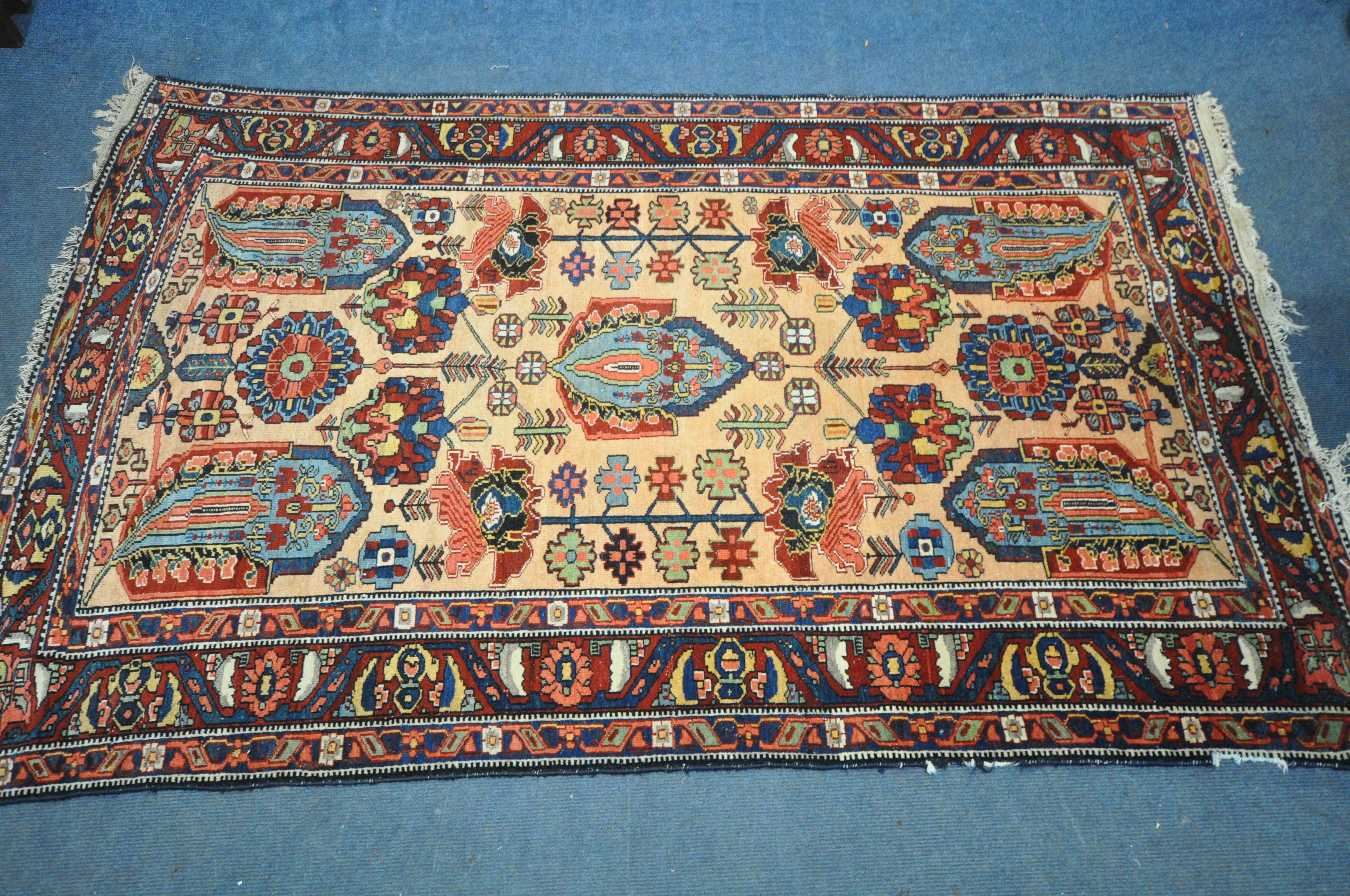 A PERSIAN MALAYER RUG, hand knotted with a repeating stylized pattern on a cream field, and
