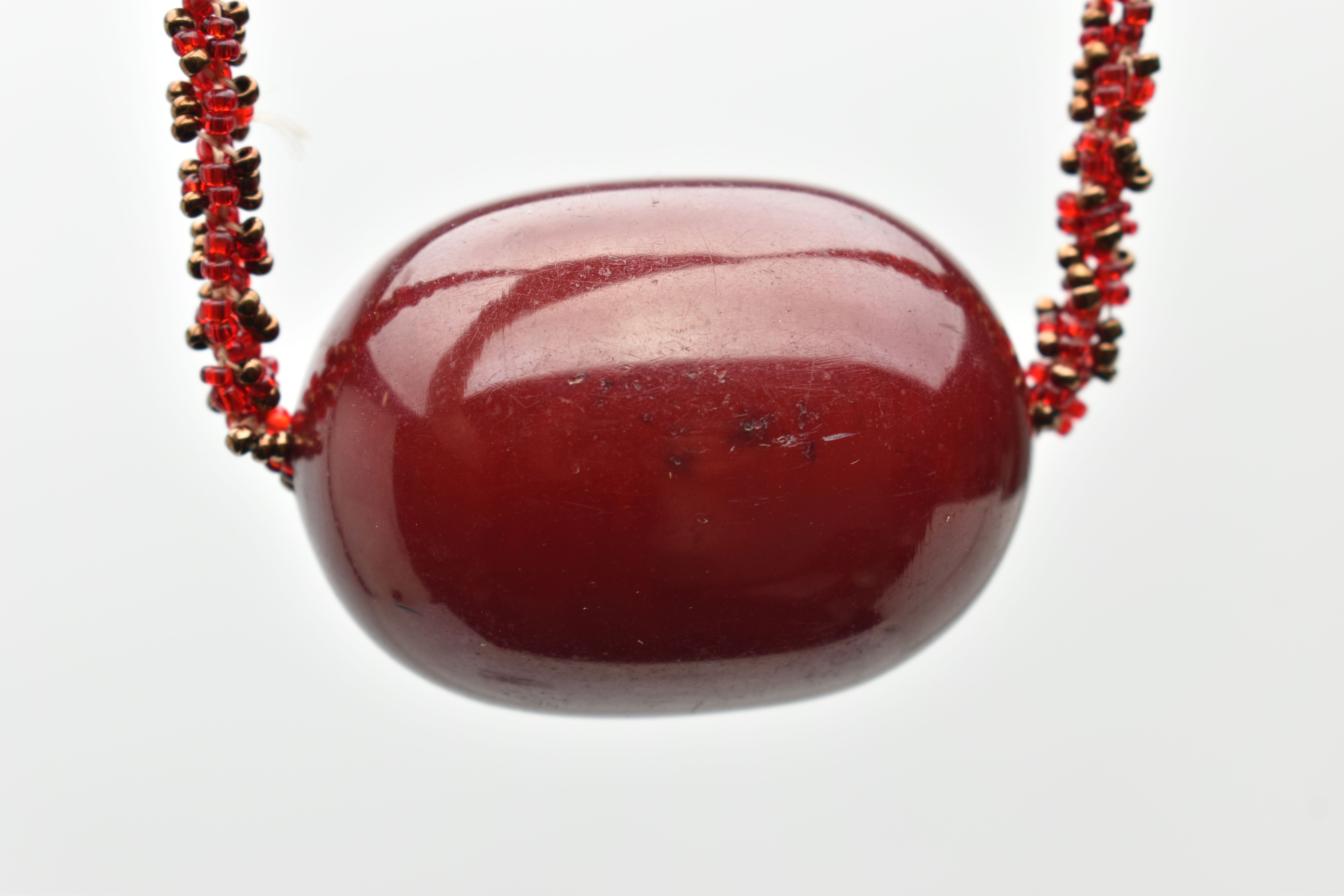 A SMALL BAG OF ITEMS, to include a large oval cherry amber colour Bakelite bead fitted on a red - Bild 6 aus 7