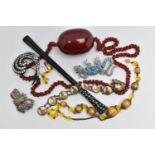 A SMALL BAG OF ITEMS, to include a large oval cherry amber colour Bakelite bead fitted on a red