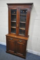 AN EDWARDIAN WALNUT GLAZED BOOKCASE, above a single drawer and double panel doors, width 89cm x