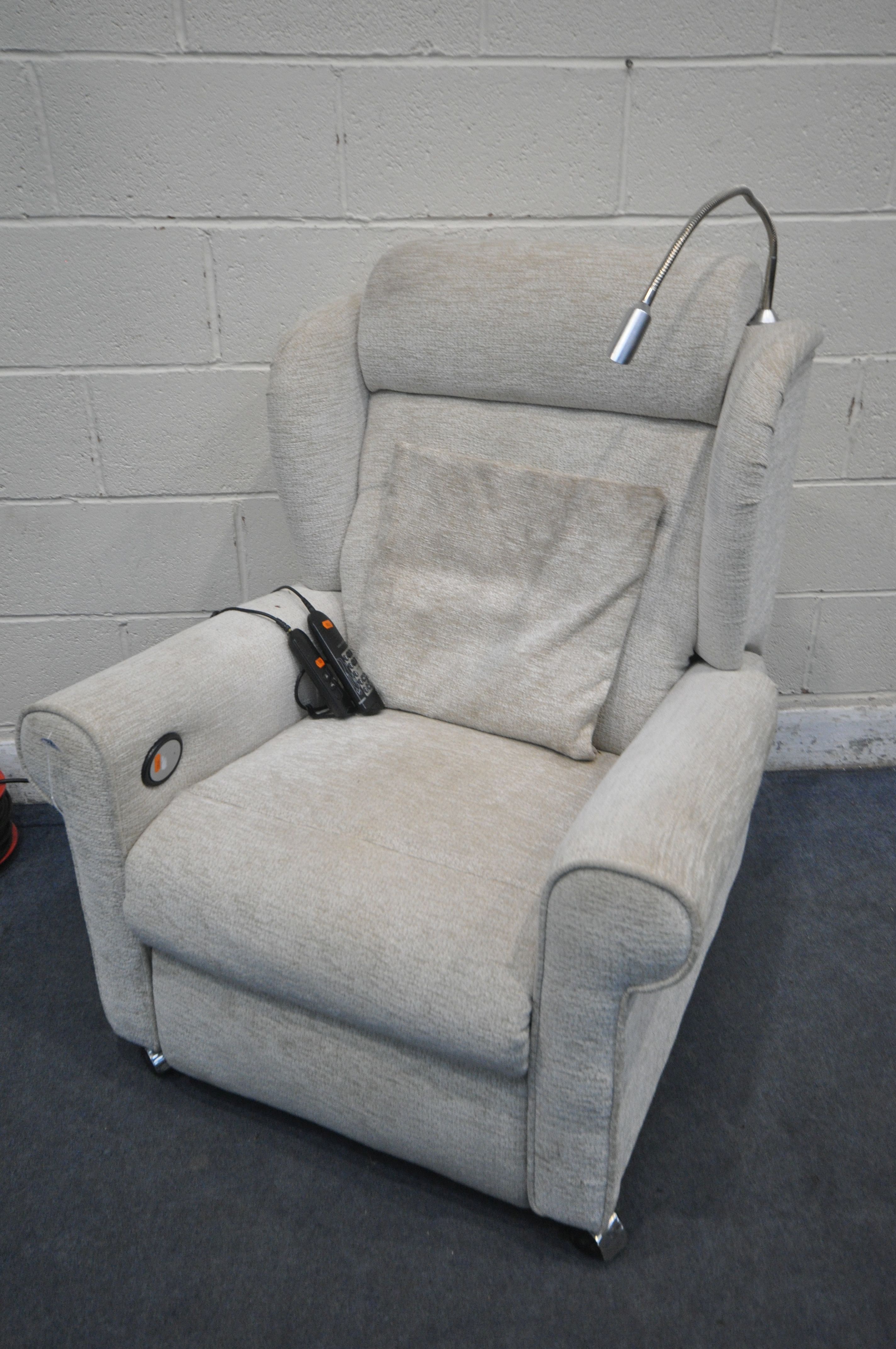 A BEIGE UPHOLSTERED ELECTRIC RISE AND RECLINE ARMCHAIR, with massaging settings (PAT pass and