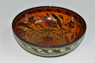 A PILKINGTON'S BOWL, decorated with flowers and foliage on a mid-green exterior and a red/orange