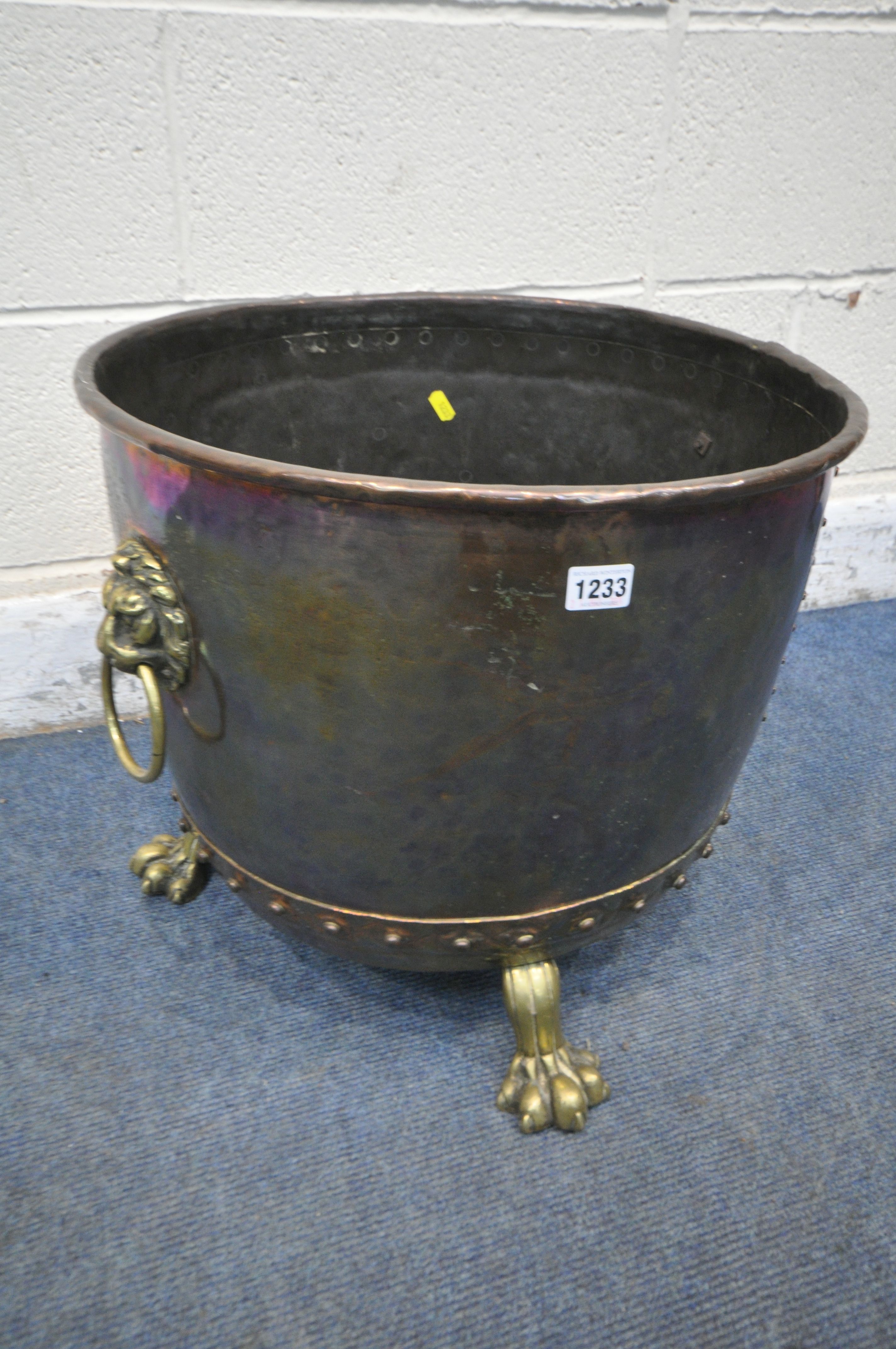 A 19TH CENTURY RIVETED BRASS AND COPPER COAL BUCKET, with lions head handles, and triple paw feet,