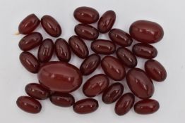 A SMALL QUANTITY OF CHERRY AMBER COLOUR BAKELITE BEADS, loose beads of an oval form, largest