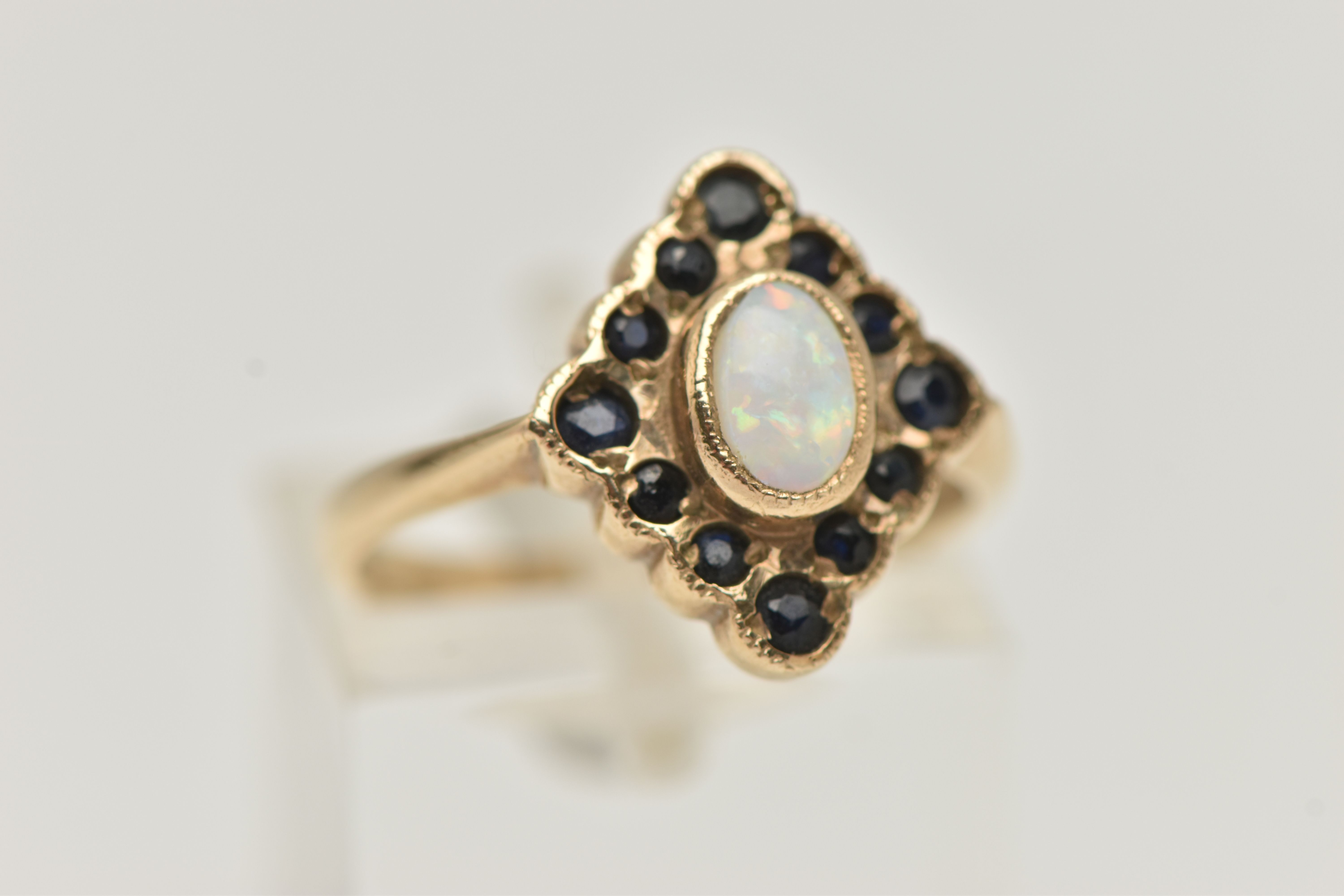 A 9CT GOLD OPAL AND SAPPHIRE RING, designed as a central oval opal cabochon within a circular - Bild 4 aus 4