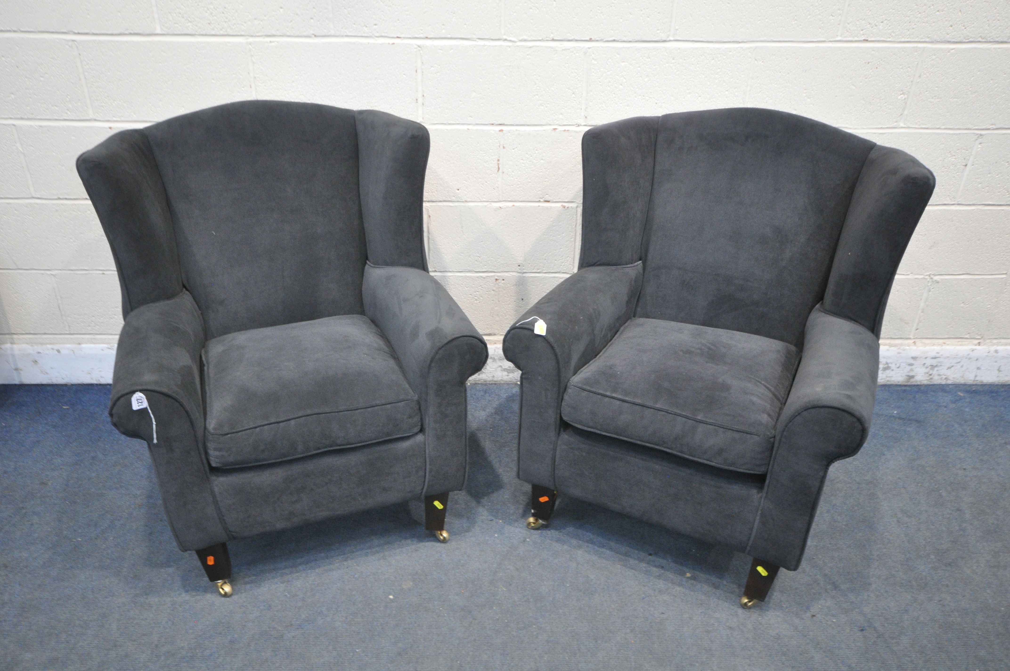 A PAIR OF DARK BLUE UPHOLSTERED ARMCHAIRS, along with a brown footstool (condition report: in need