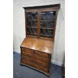 A GEORGIAN MAHOGANY BUREAU BOOKCASE, the top with blind fretwork and double astragal glazed doors,