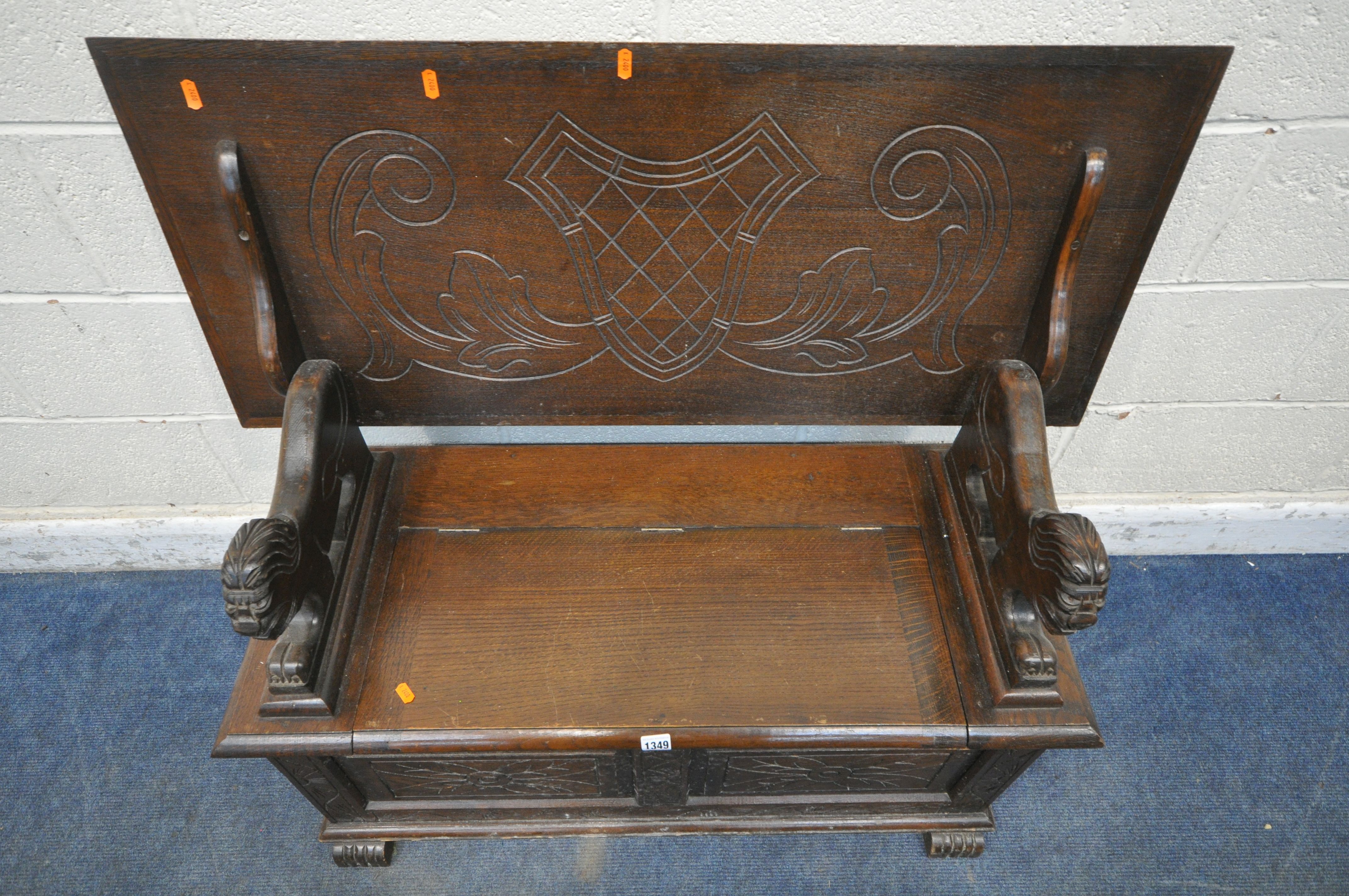 AN EARLY 20TH CENTURY OAK MONKS BENCH, with a rise and fall backrest / surface, lion armrests and - Image 3 of 4