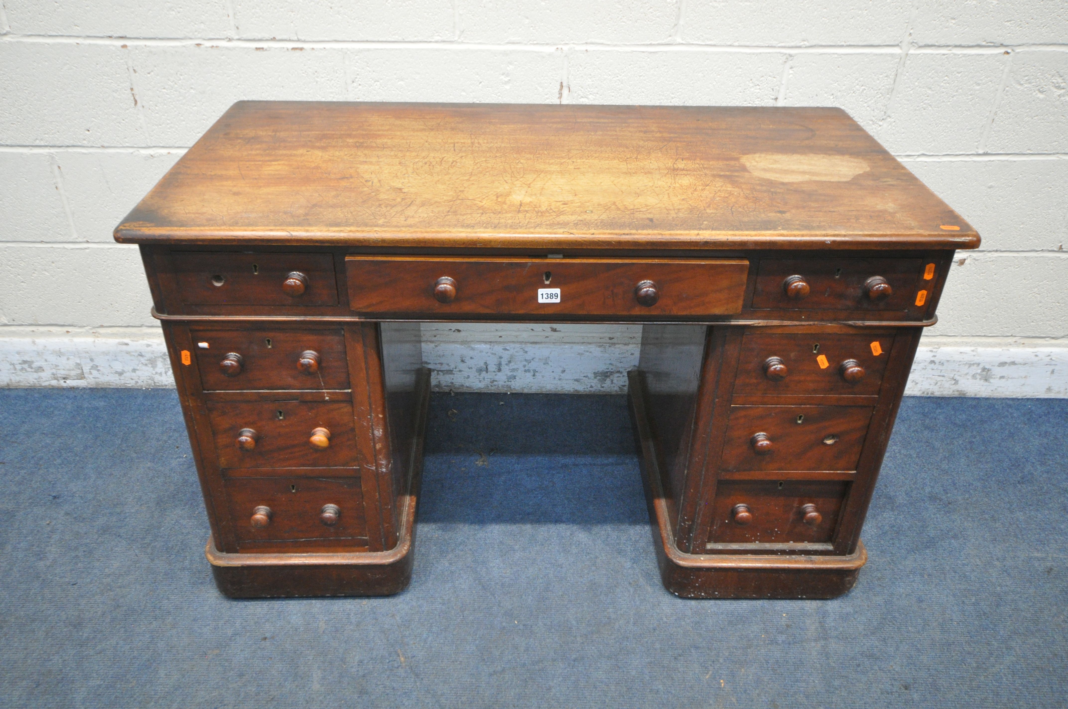 A VICTORIAN MAHOGANY TWIN PEDESTAL DESK, with an arrangement of nine drawers, on a plinth base,