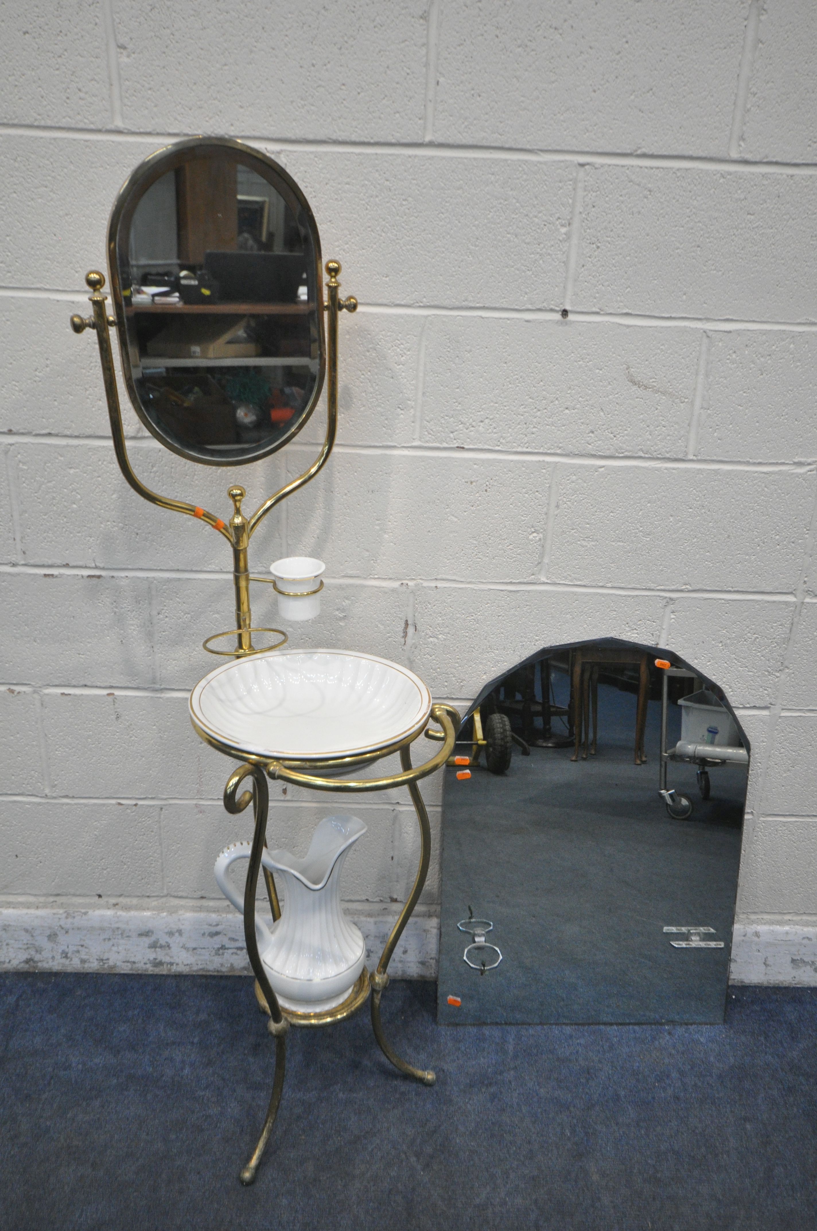 AN EARLY TO MID 20TH CENTURY BRASS FRAMED WASHSTAND, with an oval swinging mirror, ceramic jug, bowl