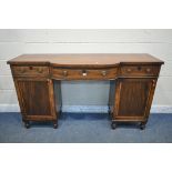 A GEORGIAN MAHOGANY AND CROSSBANDED PEDESTAL SIDEBOARD, central bowfront section, three frieze