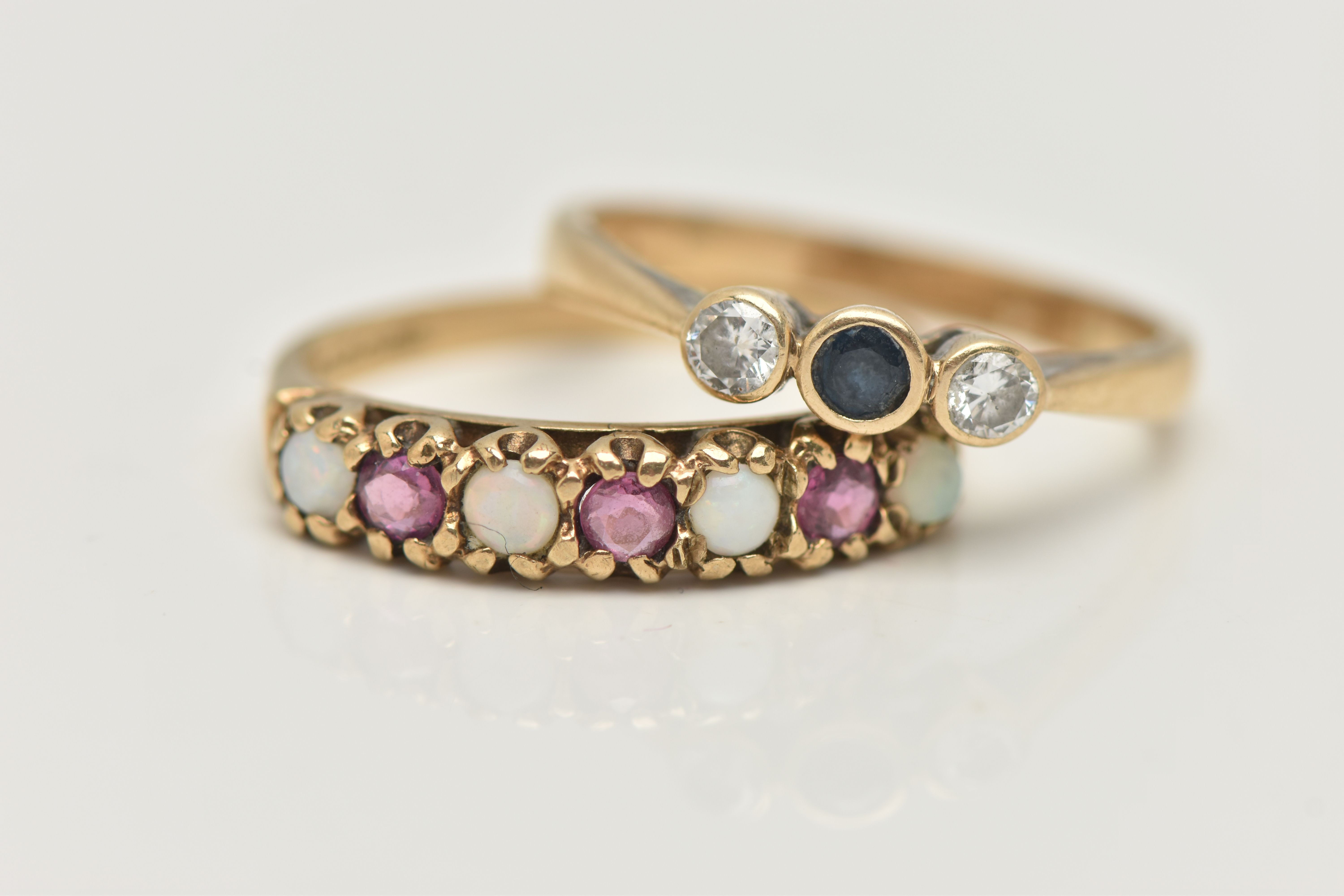 TWO 9CT GOLD GEM SET RINGS, the first designed as a central circular cut sapphire flanked by