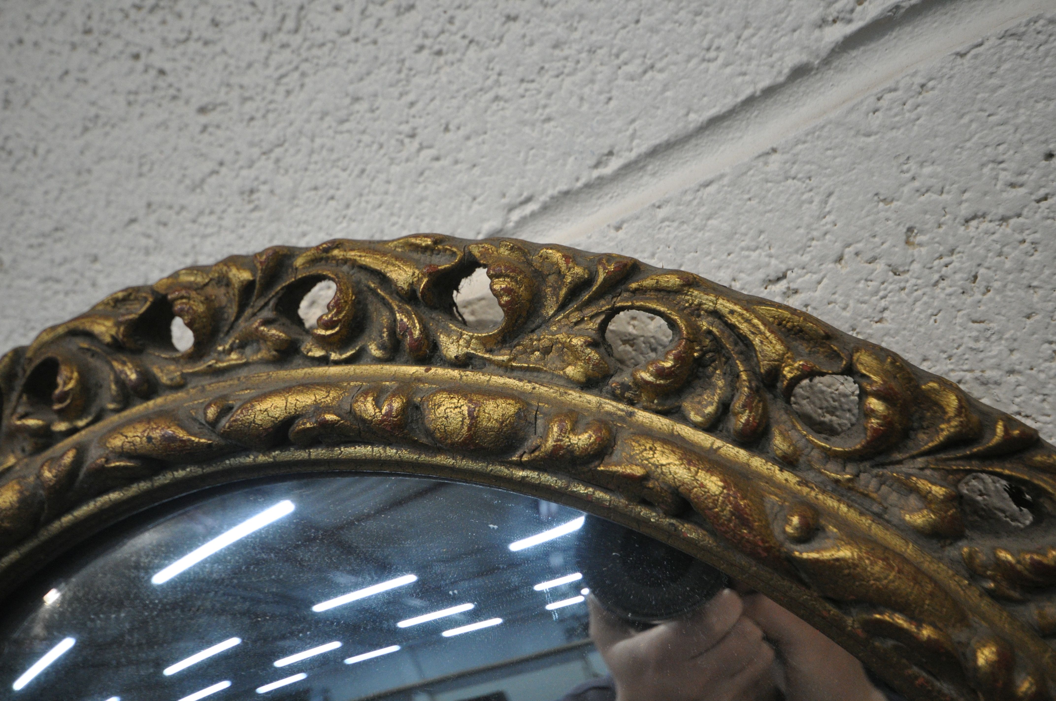 A CIRCULAR GILT FRAMED CONVEX WALL MIRROR, diameter 52cm, along with a carved oak barometer ( - Image 2 of 4