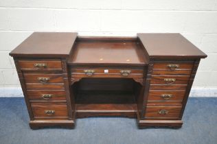 AN EDWARDIAN MAHOGANY DESK, fitted with nine drawers, on casters, width 152cm x depth 56cm x