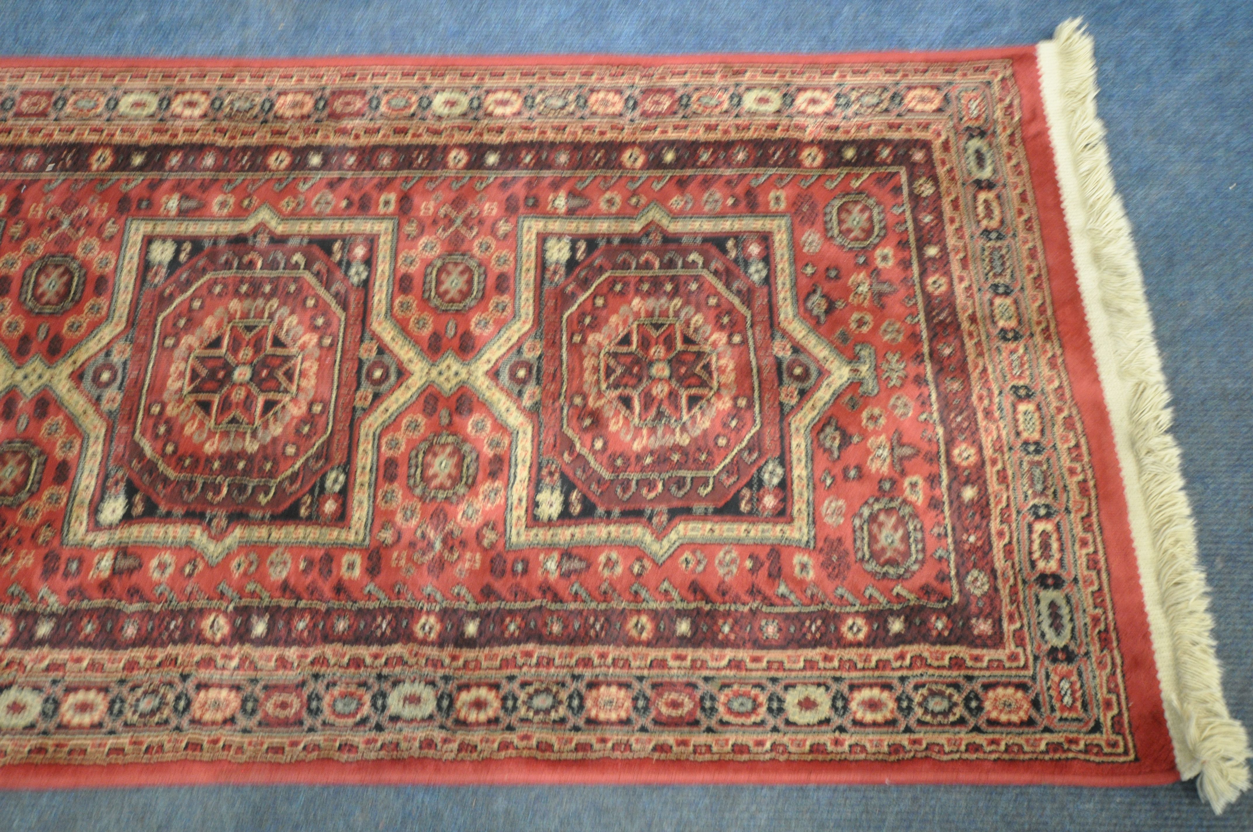 A LATE 20TH CENTURY SYNTHETIC RED PATTERNED CARPET RUNNER, 210cm (condition report: good) - Image 2 of 3