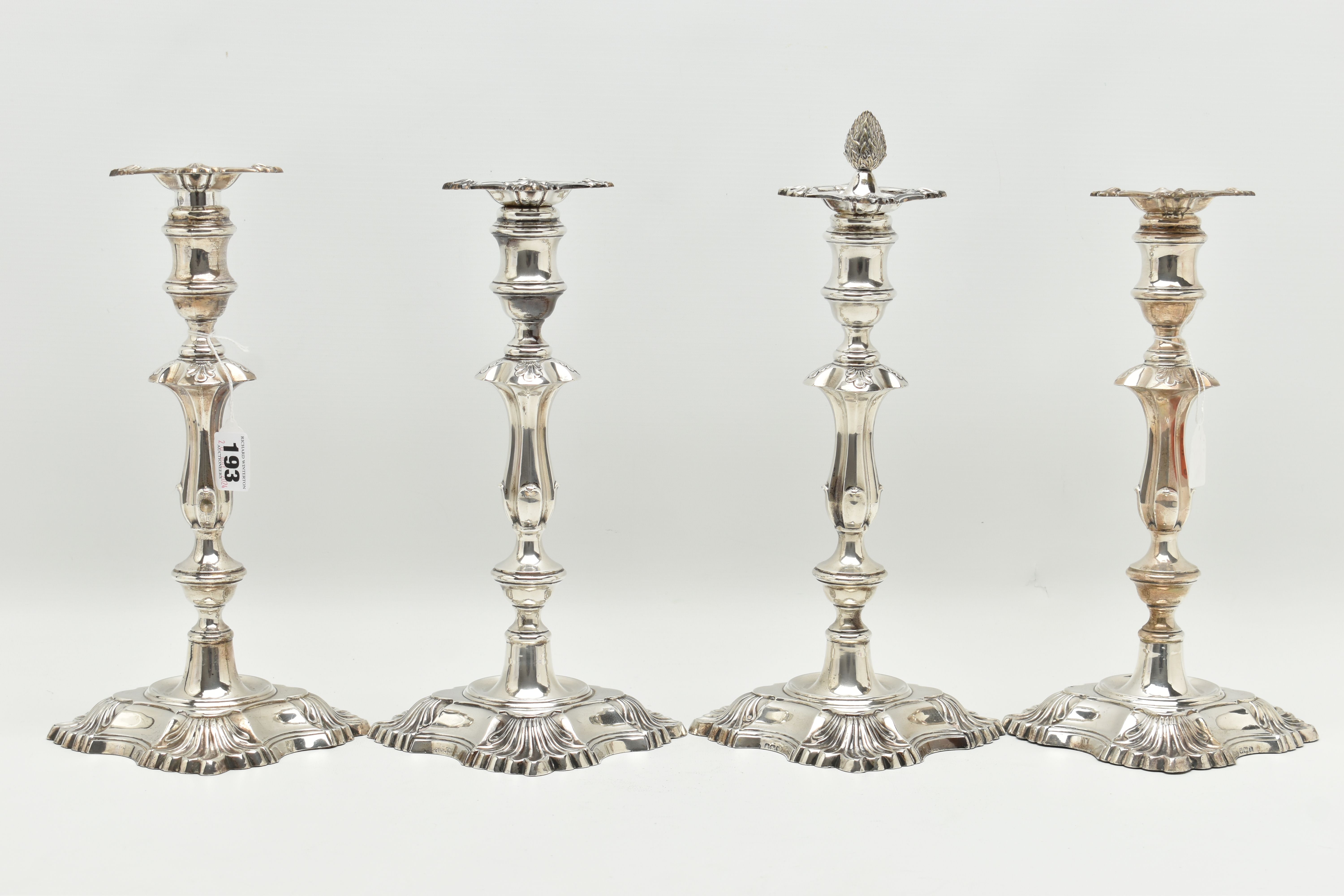 A GEORGE V SILVER SET OF FOUR CANDLESTICKS IN GEORGE II STYLE, with removable shaped square drip