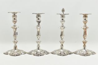 A GEORGE V SILVER SET OF FOUR CANDLESTICKS IN GEORGE II STYLE, with removable shaped square drip