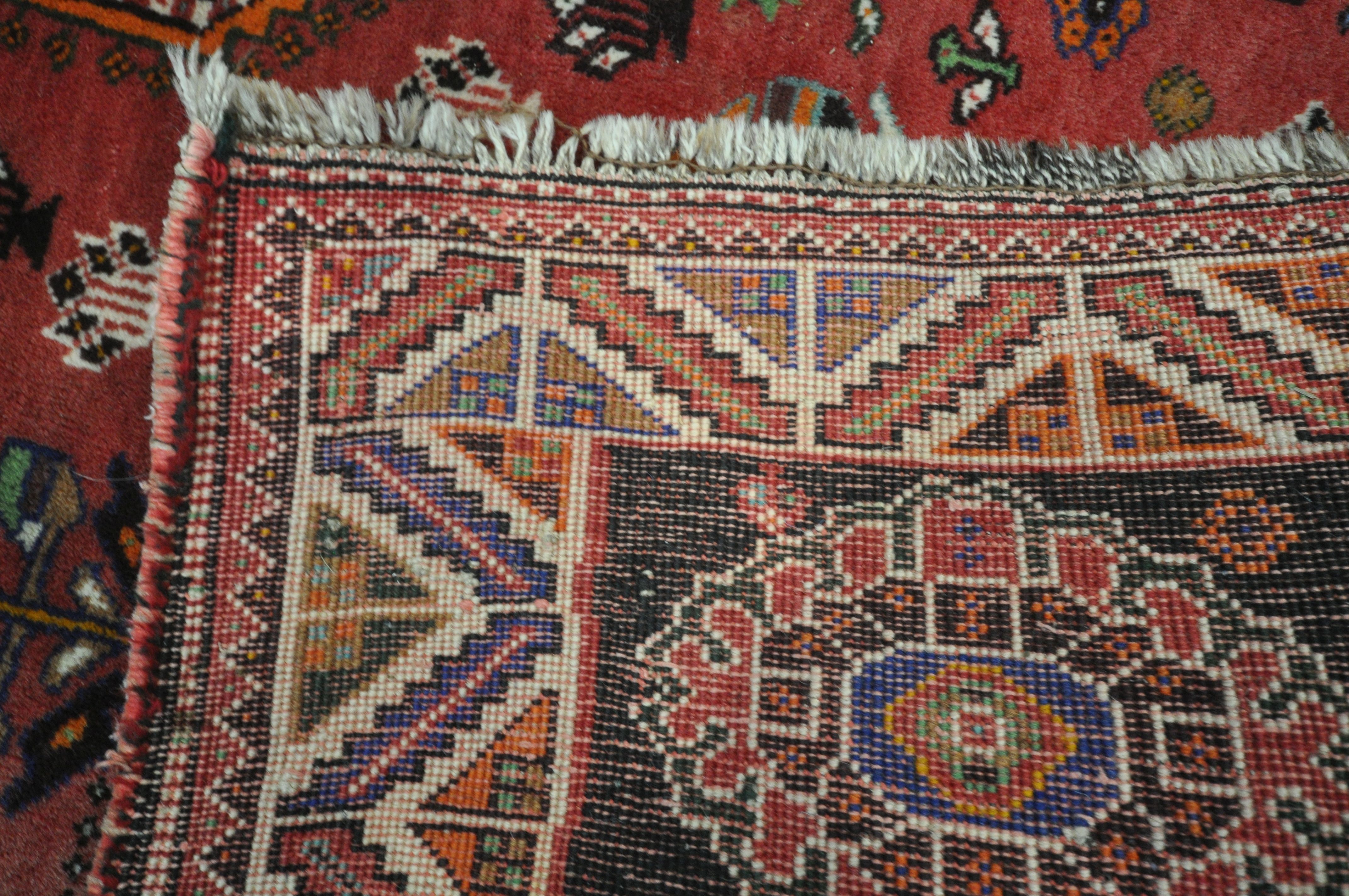 A WOOLLEN RED GROUND RUG, with a repeating pattern of birds, three central medallions, black - Image 6 of 6