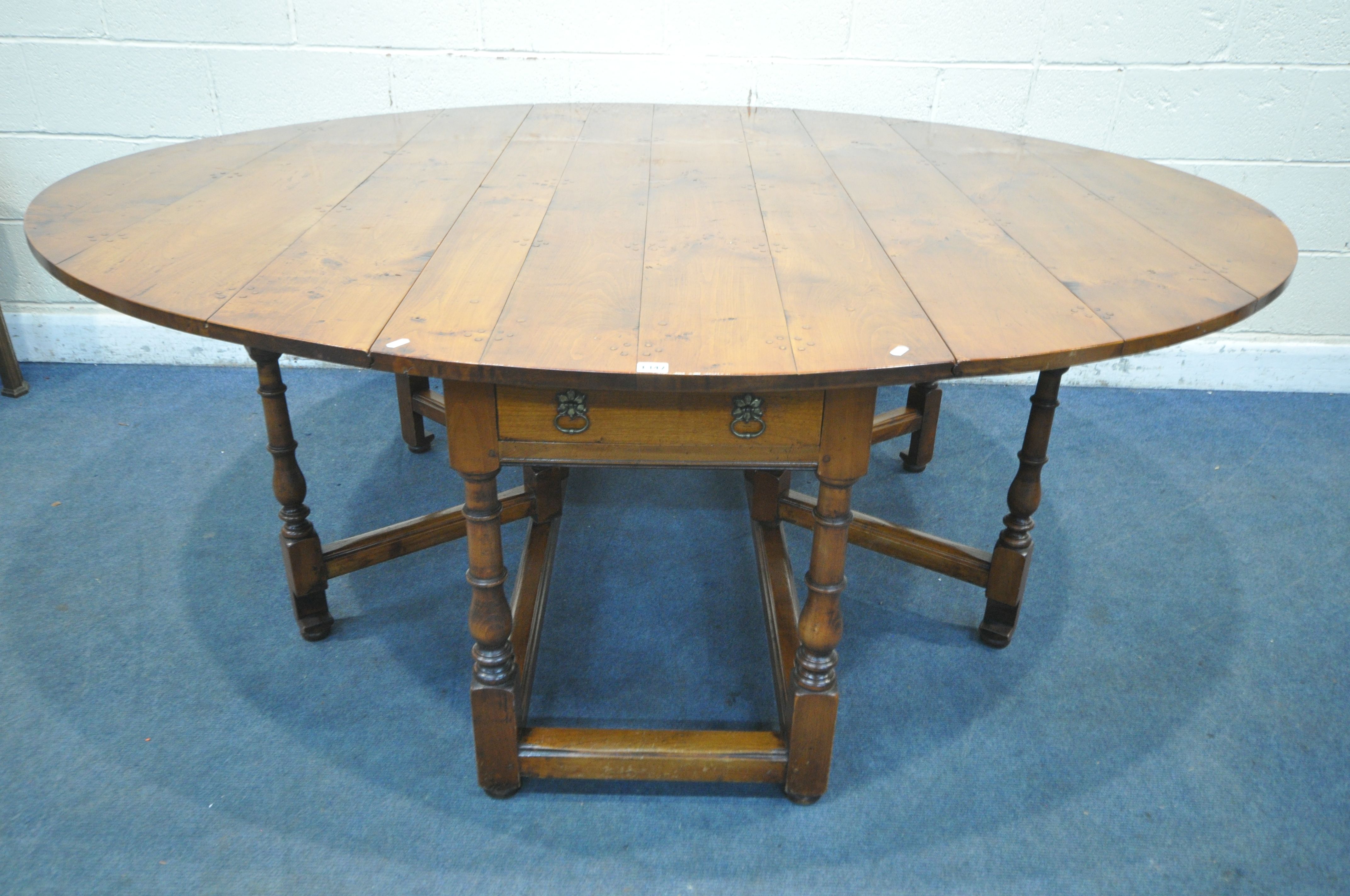 A GOOD QUALITY LARGE REPRODUCTION ELM DROP LEAF TABLE, with a single frieze drawer to each end,