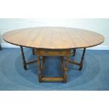 A GOOD QUALITY LARGE REPRODUCTION ELM DROP LEAF TABLE, with a single frieze drawer to each end,