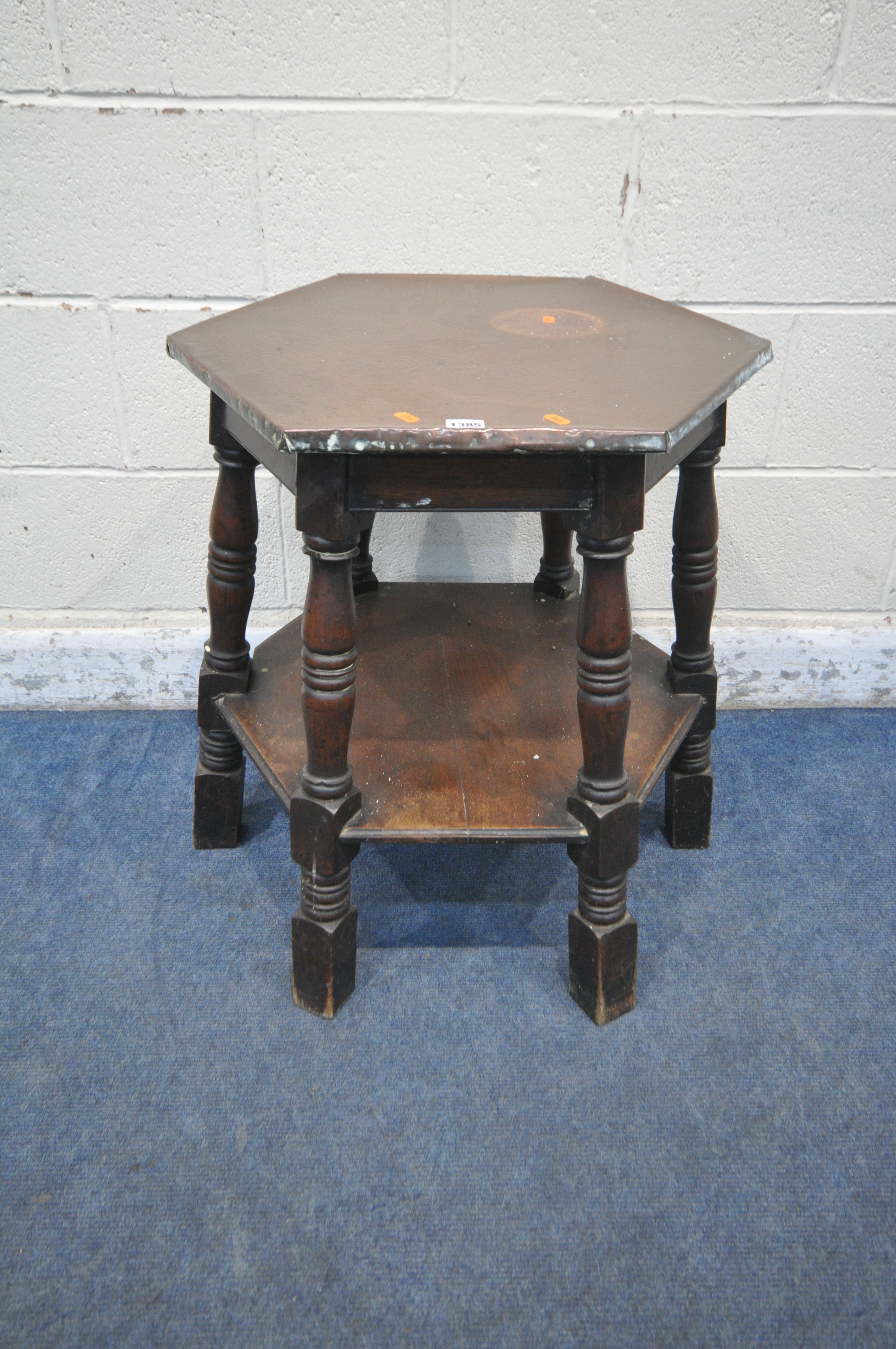 AN ARTS AND CRAFTS OAK HEXAGONAL OCCASIONAL TABLE, with a beaten copper top, raised on block and