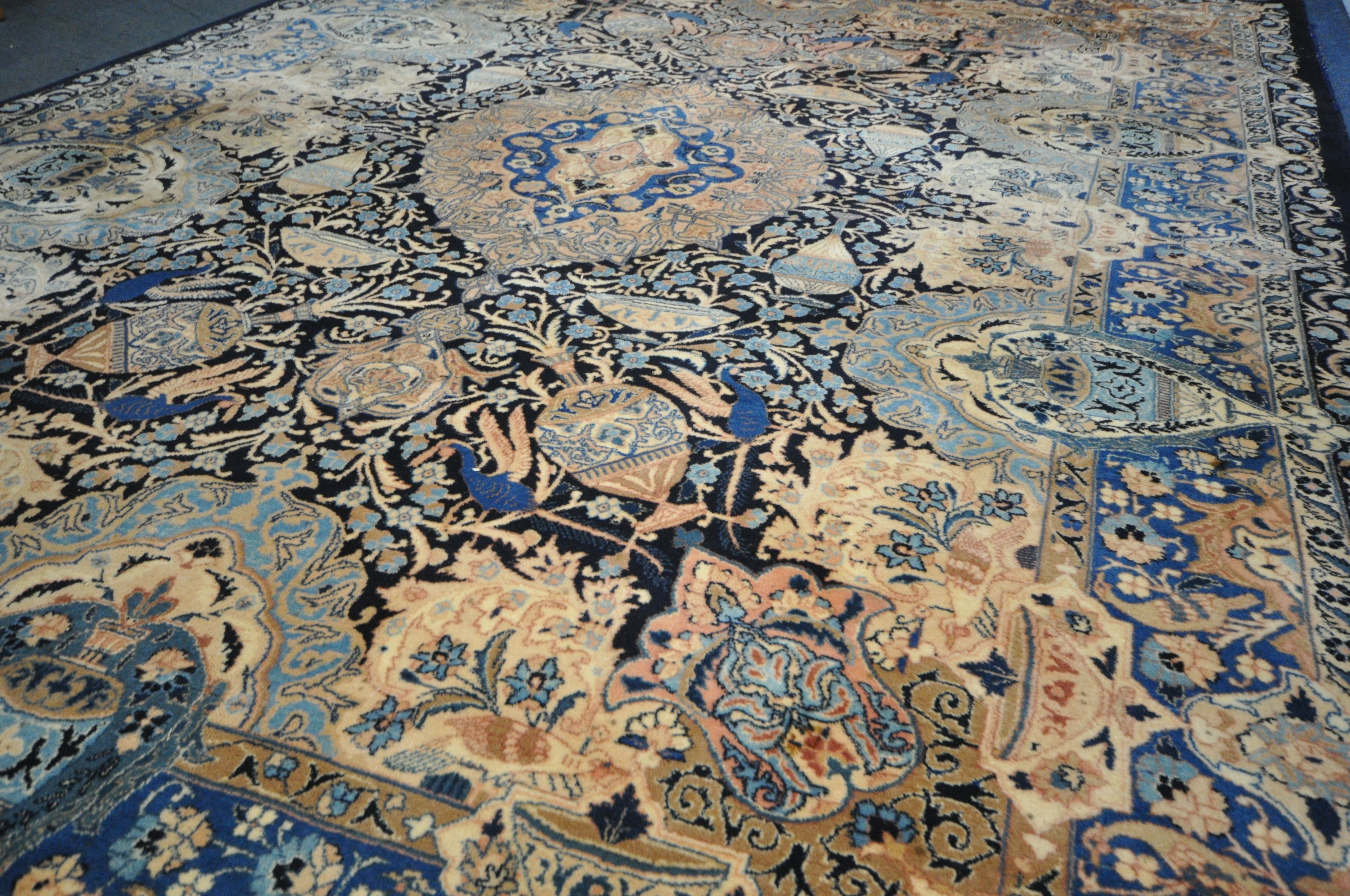 A LARGE WOOLLEN CREAM GROUND RUG, with a repeating foliate pattern, within a dark blue field, and - Image 3 of 6