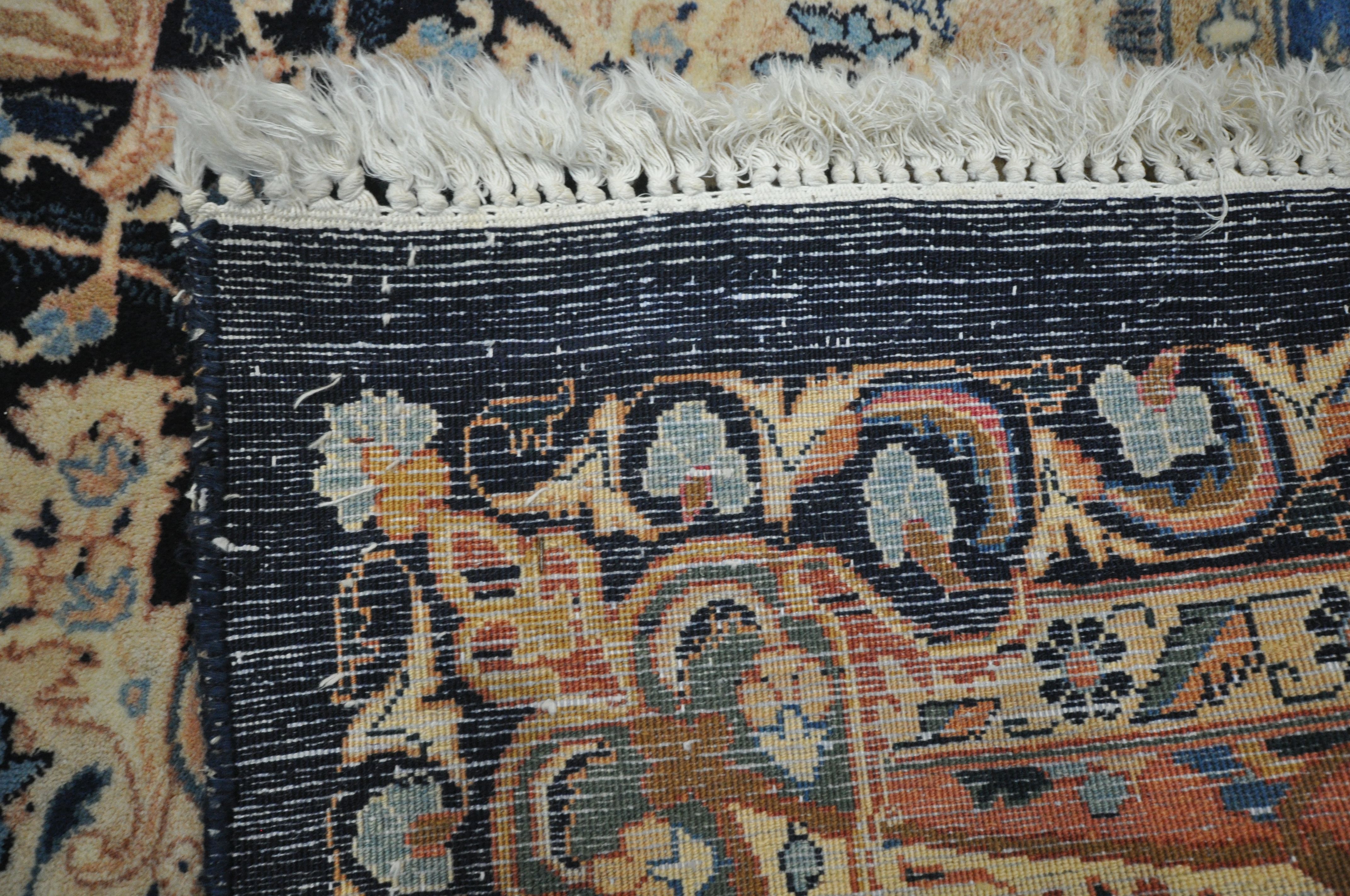 A LARGE WOOLLEN CREAM GROUND RUG, with a repeating foliate pattern, within a dark blue field, and - Image 6 of 6