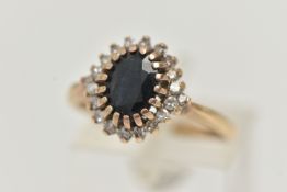 A 9CT GOLD SAPPHIRE AND DIAMOND CLUSTER RING, the central oval sapphire within a single cut