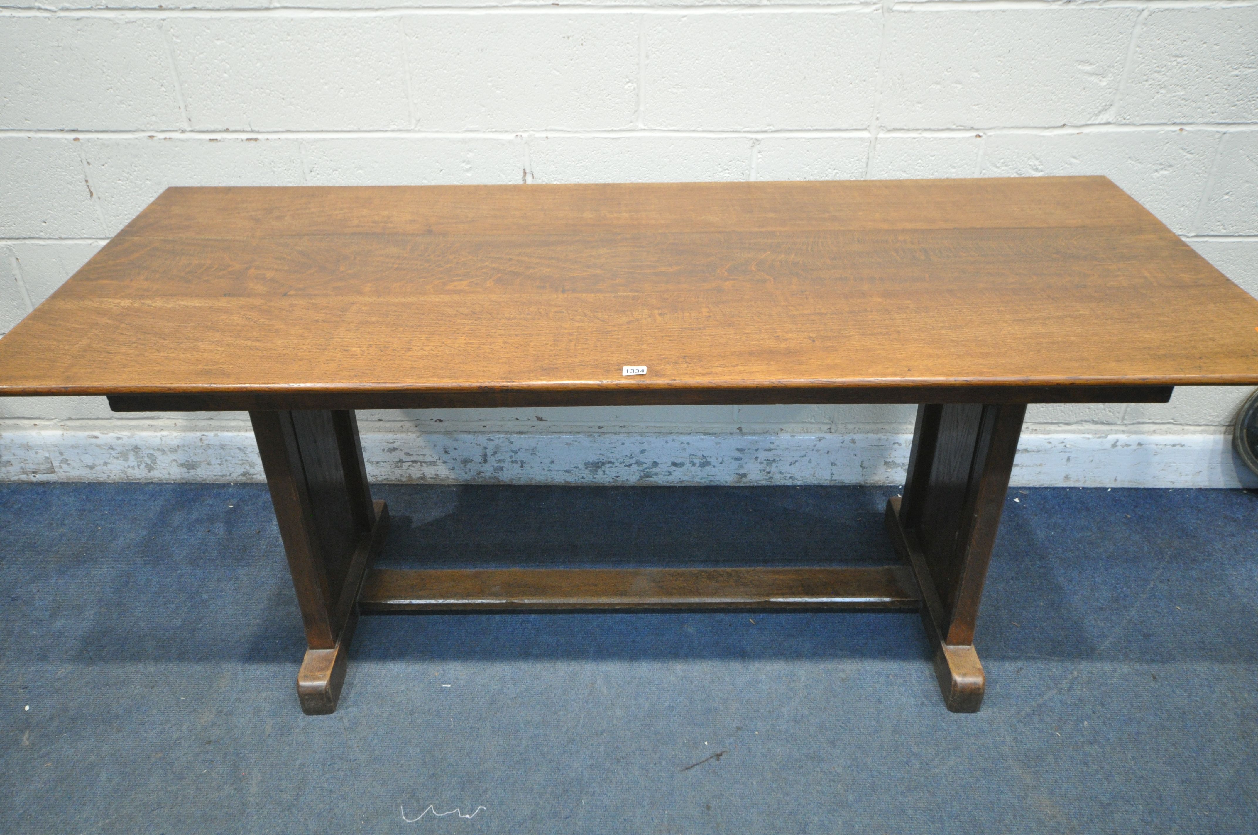 AN OAK TRESTLE DINING TABLE, united by a floor stretcher, length 182cm x 87cm x height 77cm (