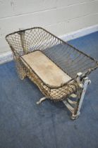 A VICTORIAN METAL FOLDING TRAVEL ROCKING CRIB (condition report: loose rope, some rust, losses to