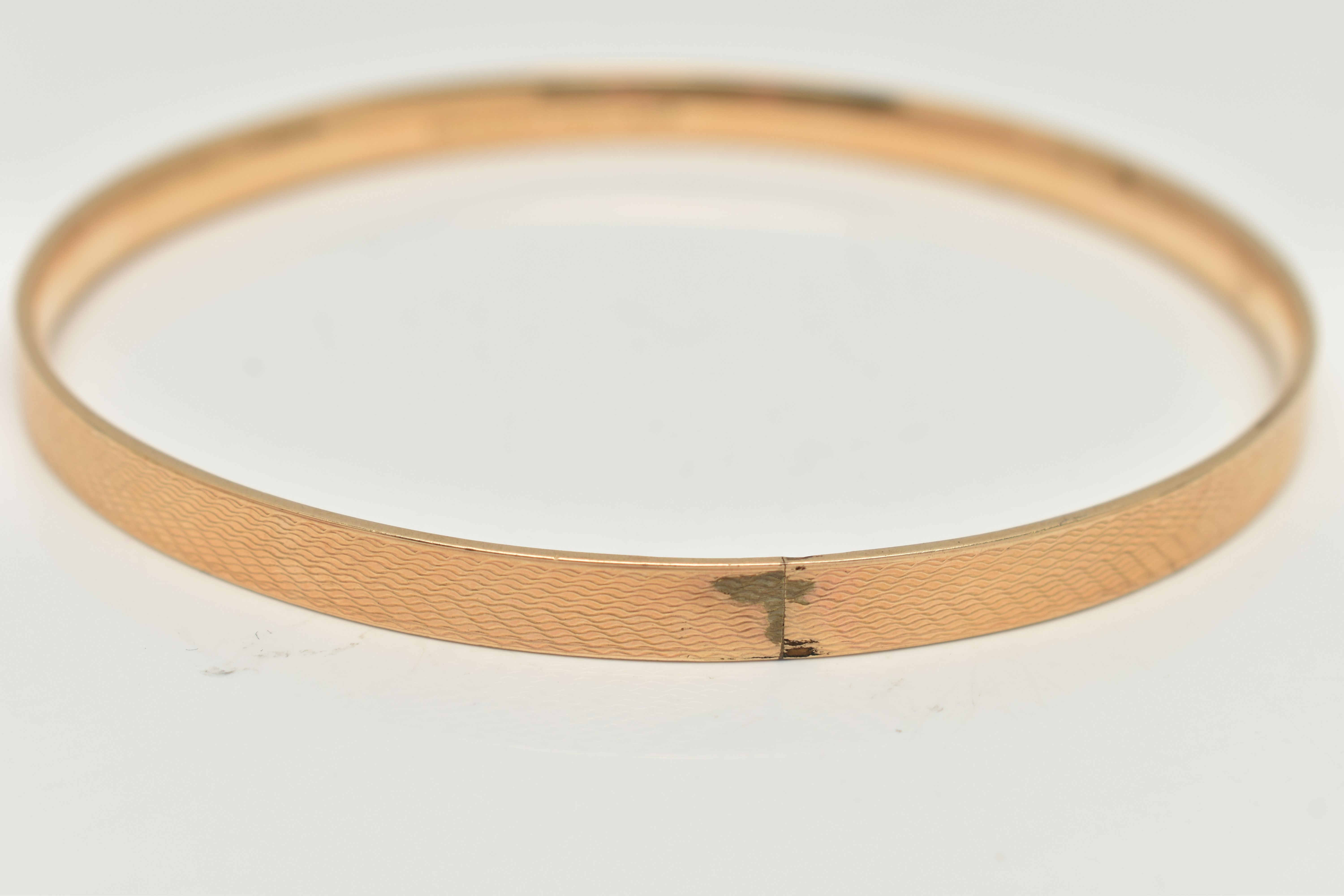 A 9CT GOLD METAL CORE BANGLE, engine turned pattern, stamped '9ct gold solid metal core', - Bild 3 aus 3