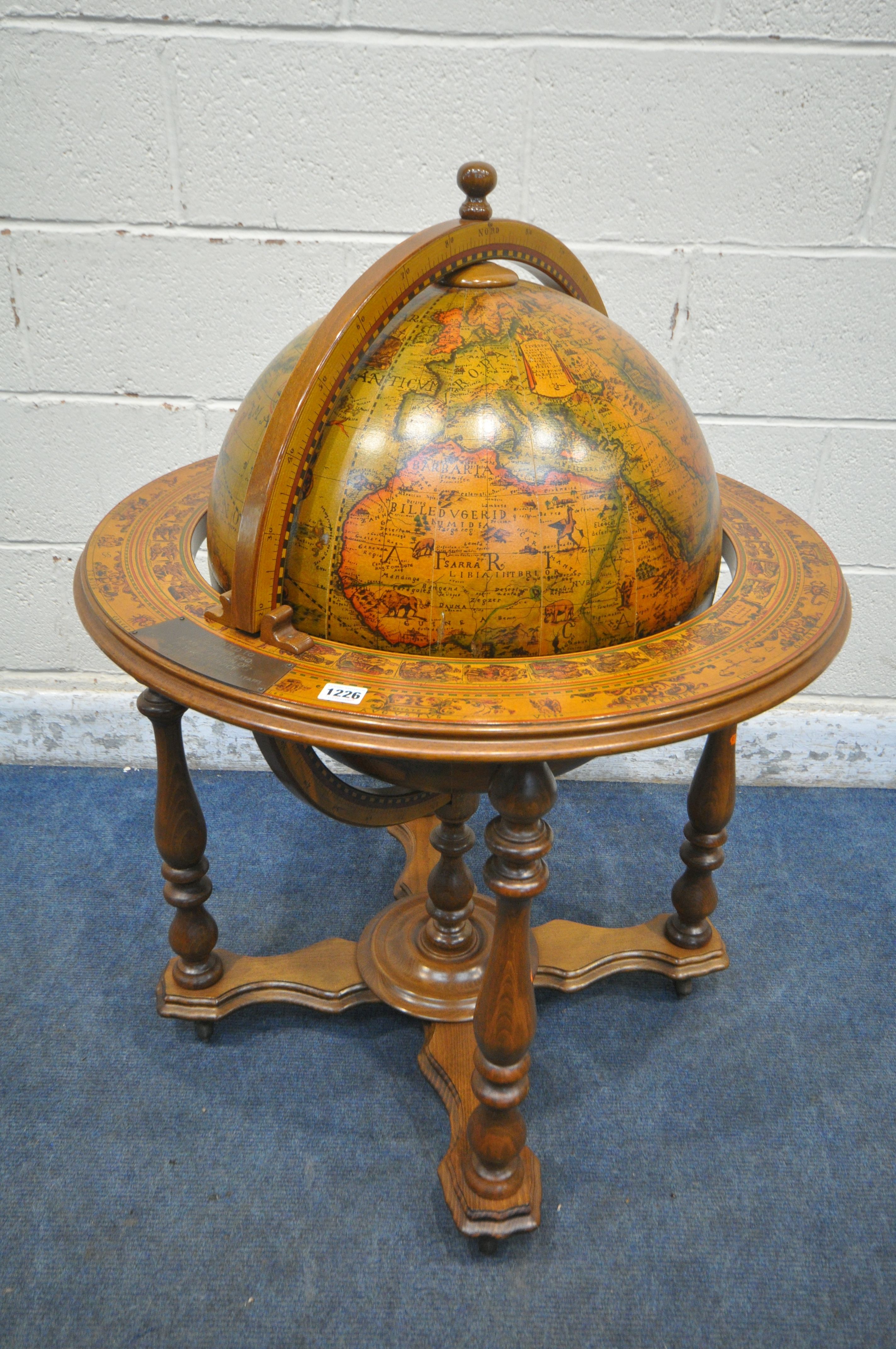 A 20TH CENTURY DRINKS GLOBE, the hinged top enclosing a fitted interior, on turned legs united by