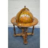 A 20TH CENTURY DRINKS GLOBE, the hinged top enclosing a fitted interior, on turned legs united by