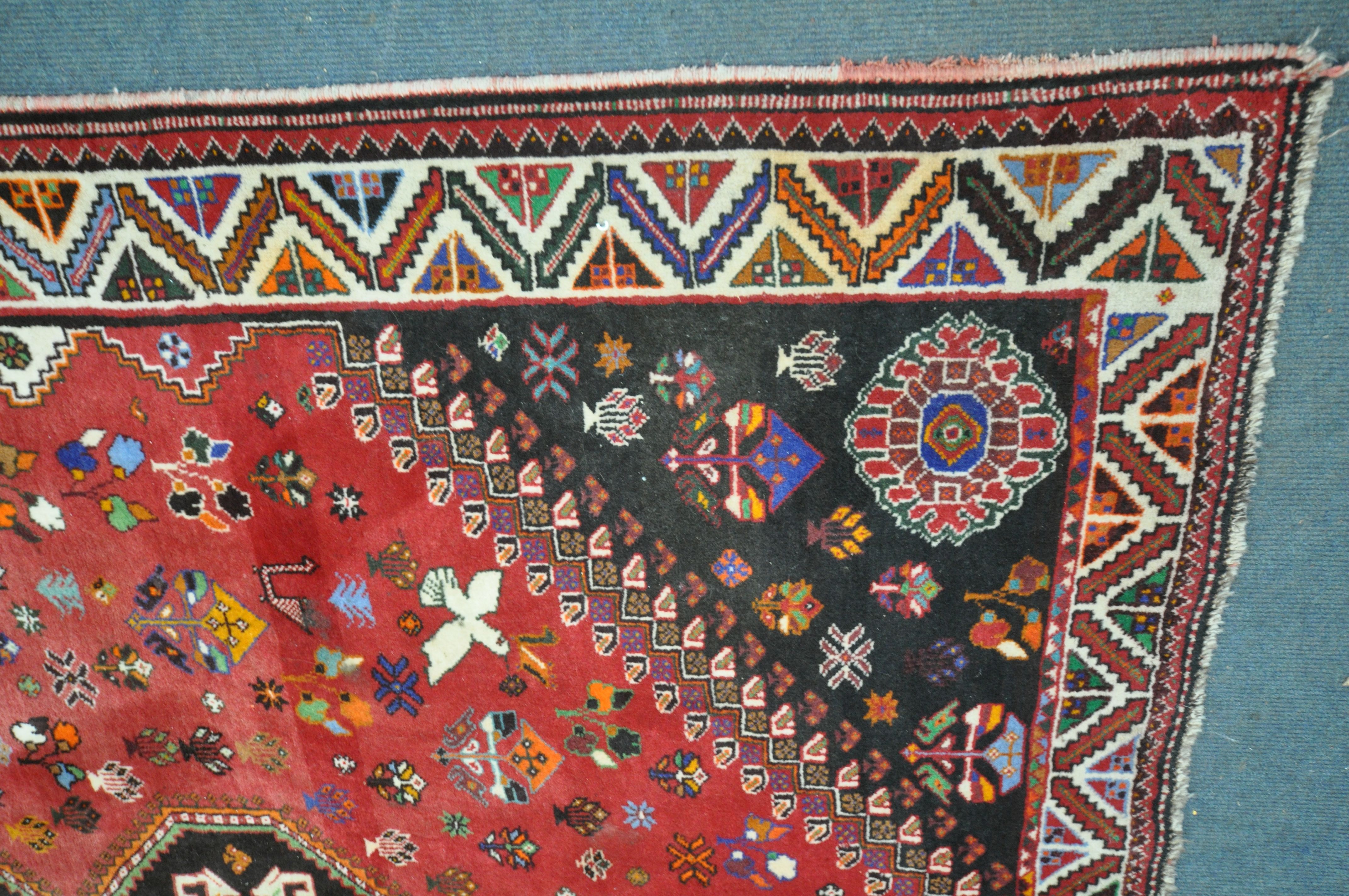 A WOOLLEN RED GROUND RUG, with a repeating pattern of birds, three central medallions, black - Image 2 of 6