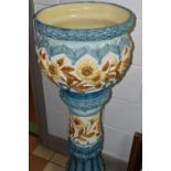 A LARGE 19TH CENTURY BURMANTOFT FAIENCE JARDINIERE AND STAND, relief decorated panels of brown
