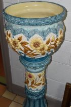 A LARGE 19TH CENTURY BURMANTOFT FAIENCE JARDINIERE AND STAND, relief decorated panels of brown
