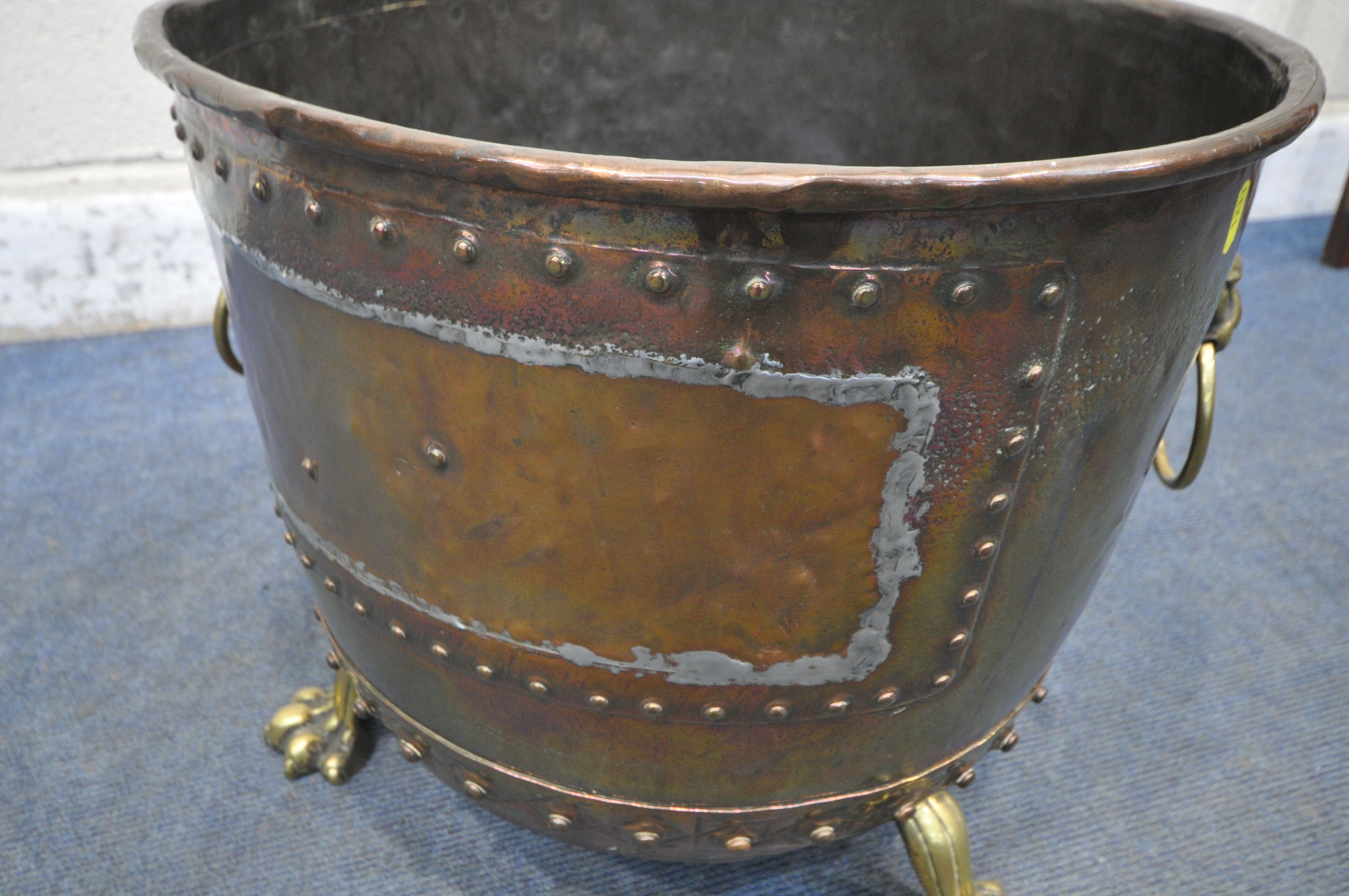 A 19TH CENTURY RIVETED BRASS AND COPPER COAL BUCKET, with lions head handles, and triple paw feet, - Image 4 of 5
