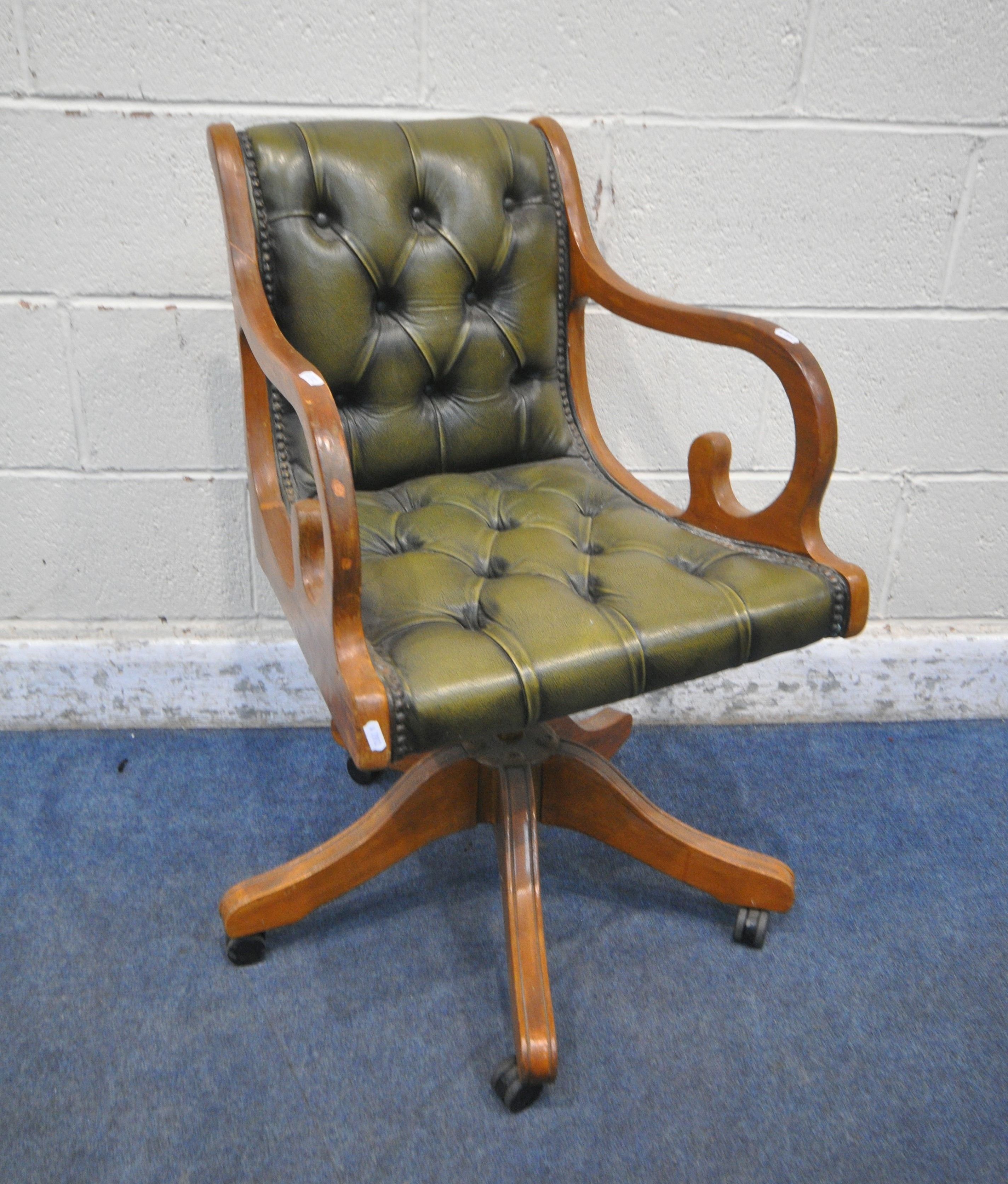 A 20TH CENTURY GREEN LEATHER BUTTONED OFFICE CHAIR (condition report: missing castor, surface marks,