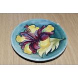A MOORCROFT POTTERY 'HIBISCUS' PATTERN TRINKET DISH, tube lined with red, purple and yellow hibiscus