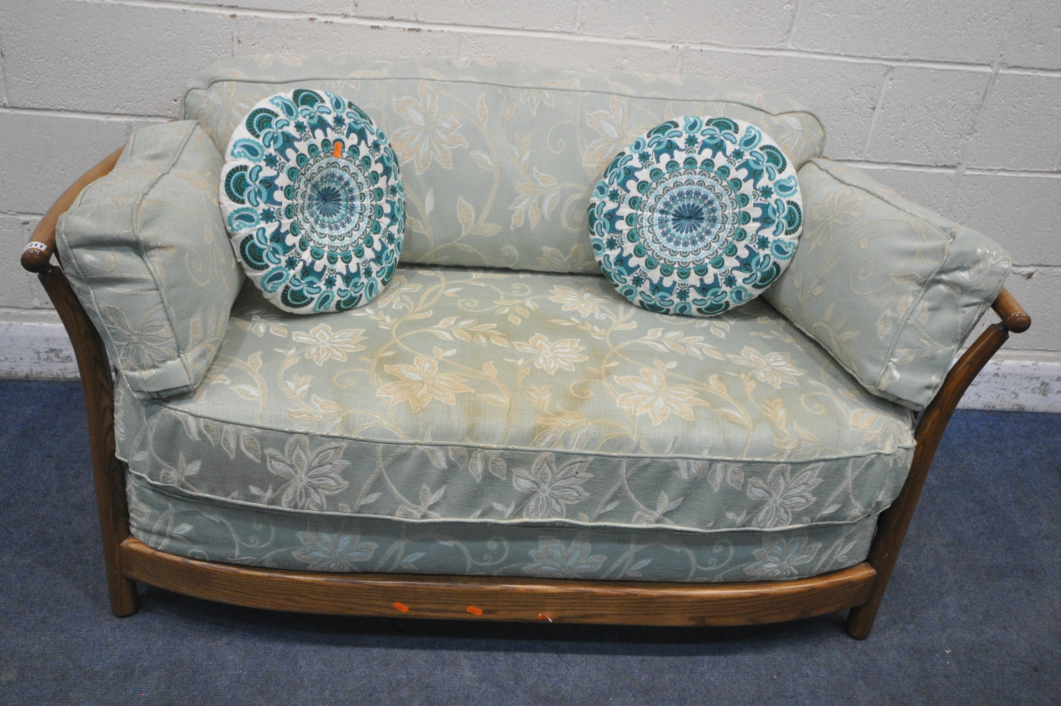A LATE 20TH CENTURY ERCOL ASH TWO SEATER SOFA, with mint green and foliate upholstery, length