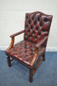 AN OXBLOOD BUTTONED LEATHER GAINSBOROUGH CHAIR, with arched back rest and open armrests, width
