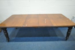 AN EDWARDIAN MAHOGANY WIND OUT DINING TABLE, with two additional leaves, raised on turned legs,