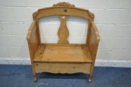 AN EARLY 20TH PINE HALL SETTLE, the arched top with a scrolled crest, a central splat back, a