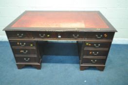 A 20TH CENTURY MAHOGANY TWIN PEDESTAL DESK, with red leather writing surface, fitted with eight