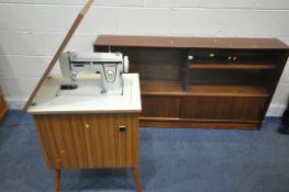 HERBERT GIBBS, A MID CENTURY TEAK BOOKCASE, with double smoked glass doors, above double sliding