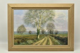 CLIVE MADGWICK ( 1934-2005) A LANDSCAPE WITH TREES AND DISTANT CHURCH, depicting a male figure