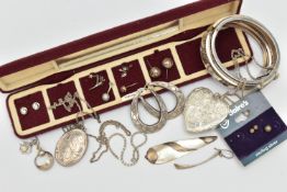 A SELECTION OF SILVER AND WHITE METAL JEWELLERY, to include a hinged bangle, a heart shape locket,