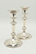 A PAIR OF GEORGE V SILVER OCTAGONAL AND MULTI FACETED CANDLESTICKS RETAILED BY ASPREY, fixed